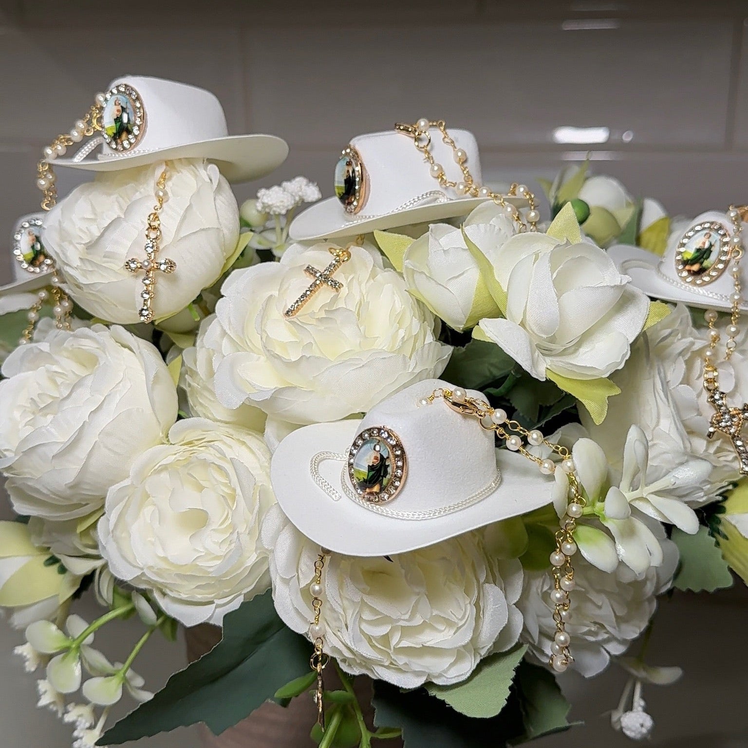 White cowboy hats with decorative elements on a bouquet of white flowers