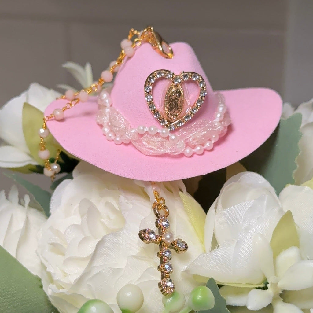 Pink cowboy hat with heart design on a bouquet of white flowers.
